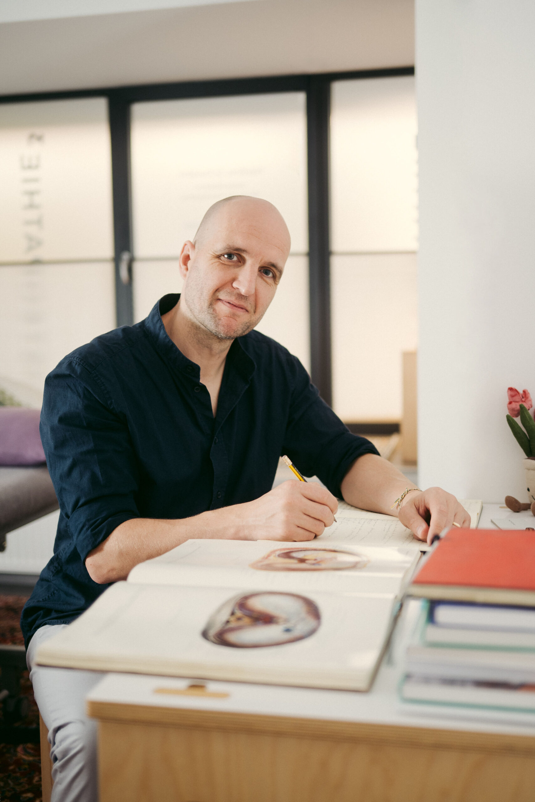 Philipp Gehrke am Schreibtisch mit einer anatomischen Abbildung