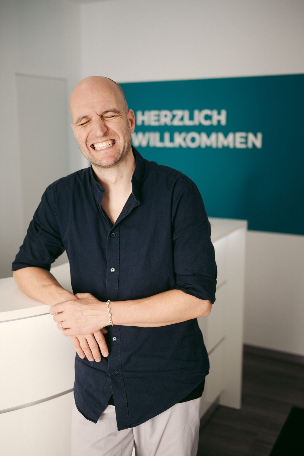 Philipp Gehrke lächelnd am Empfang seiner Osteopathiepraxis