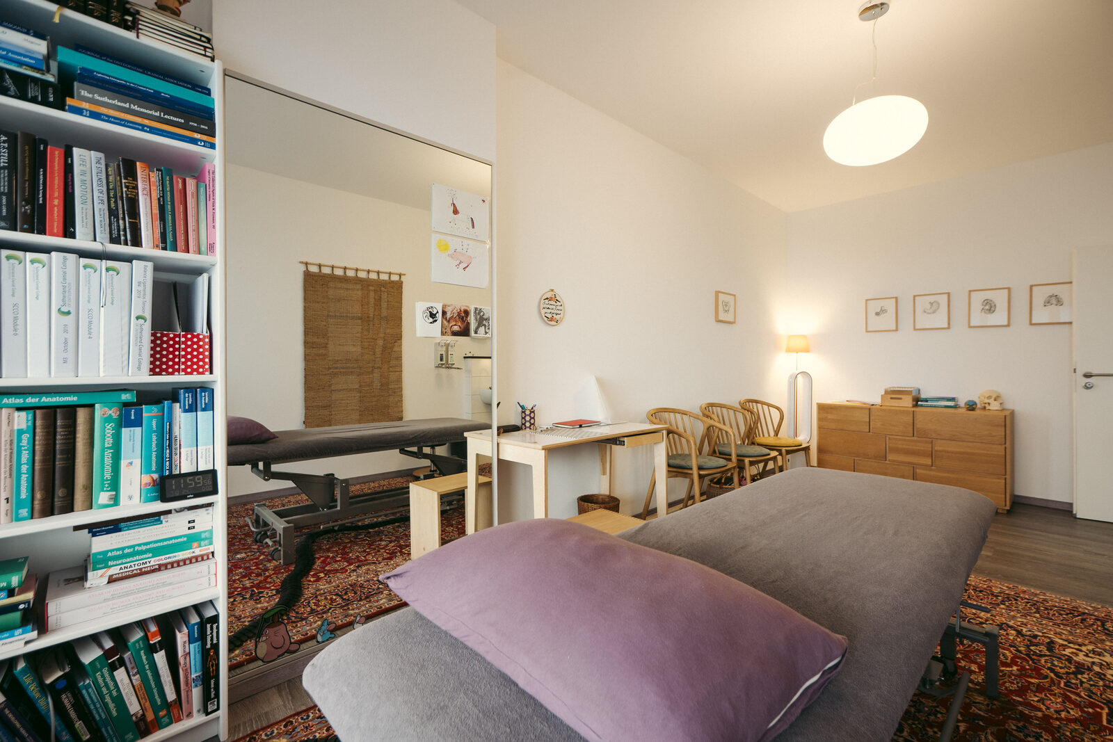 Behandlungsliege und Fachbibliothek in der Osteopathiepraxis