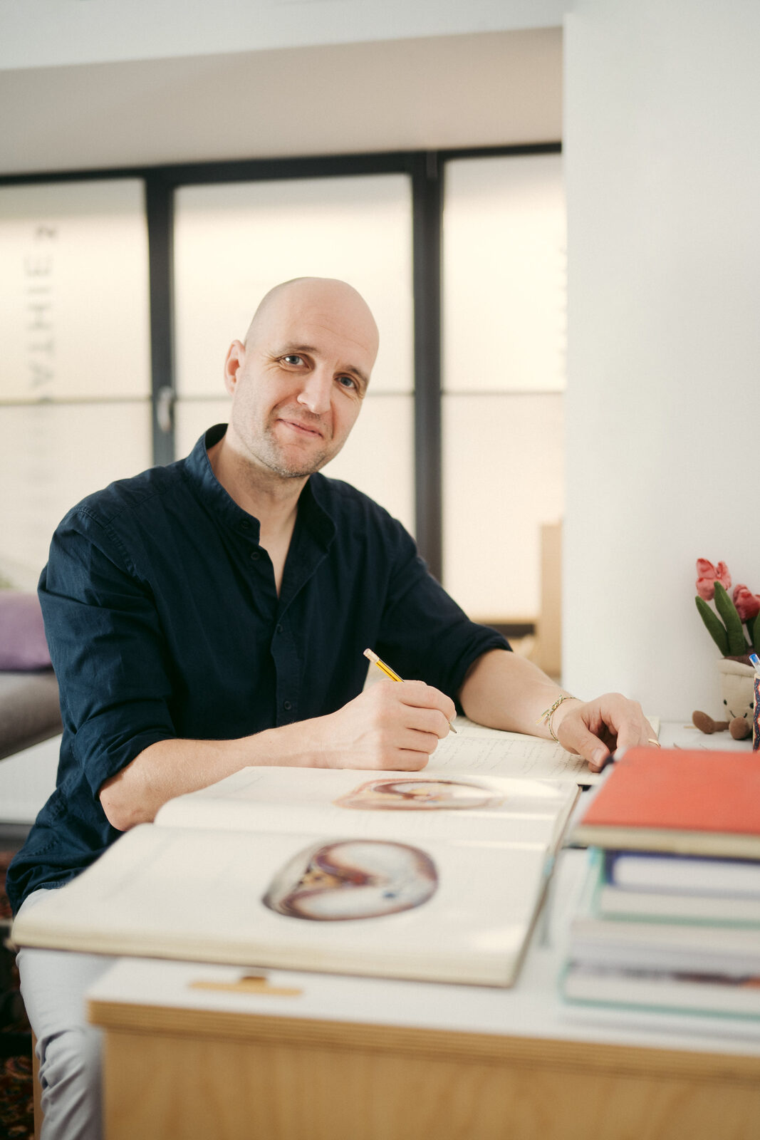 Philipp Gehrke am Schreibtisch mit einem Anatomiebuch