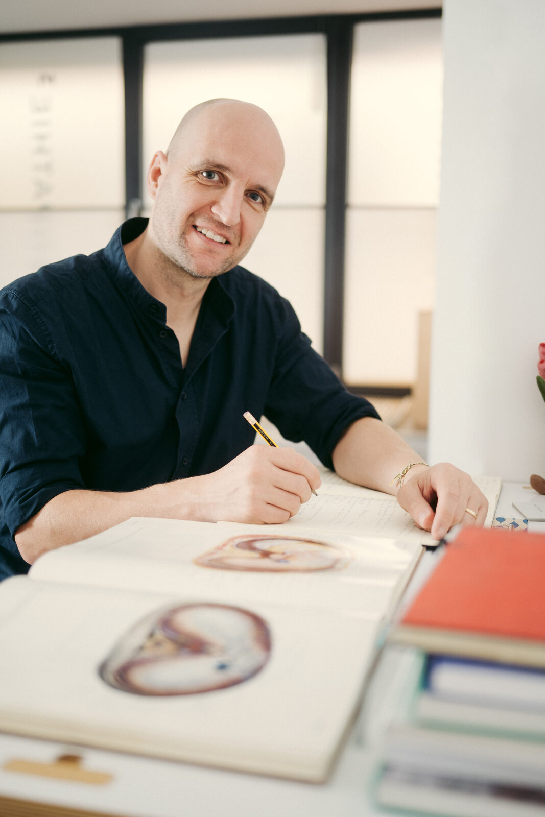 Philipp Gehrke lächelnd am Schreibtisch seiner Praxis